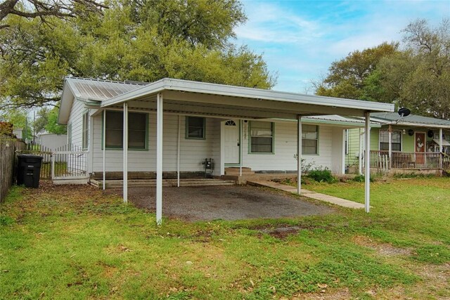 1116-C Simpson St, Schulenburg, TX 78956 - view of front of house with fence, metal roof, a porch, a front yard, and an attached carport