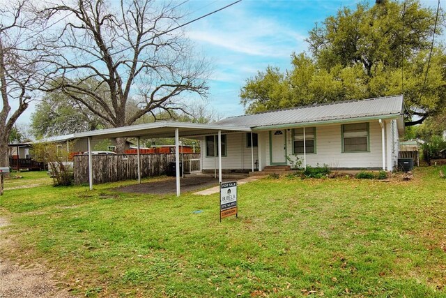 1116-C Simpson St, Schulenburg, TX 78956 - view of front of property with a front lawn, metal roof, an attached carport, and fence