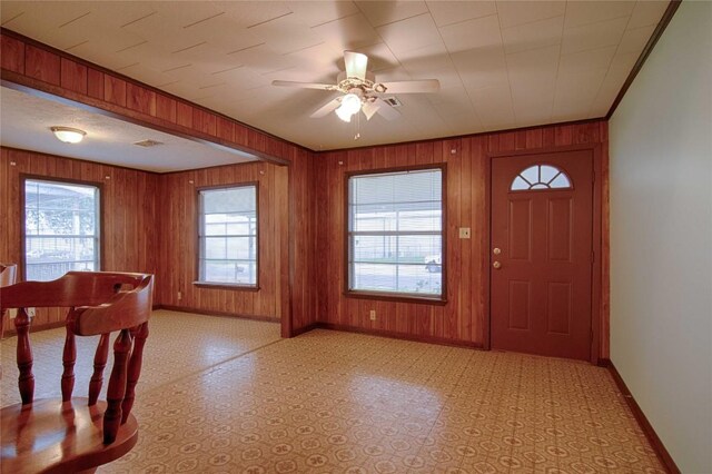1116-C Simpson St, Schulenburg, TX 78956 - foyer entrance with baseboards, a ceiling fan, wood walls, and a healthy amount of sunlight