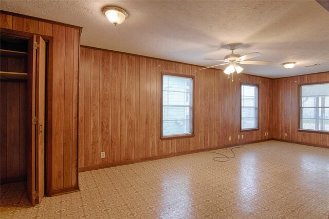 1116-C Simpson St, Schulenburg, TX 78956 - unfurnished bedroom featuring light floors, wood walls, baseboards, and a textured ceiling