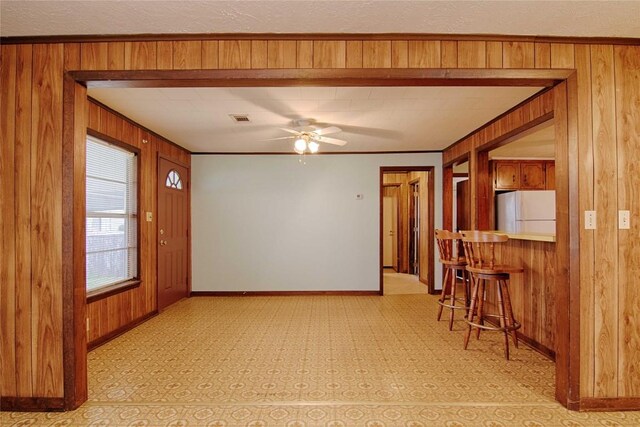 1116-C Simpson St, Schulenburg, TX 78956 - foyer entrance featuring visible vents, wooden walls, baseboards, ornamental molding, and ceiling fan