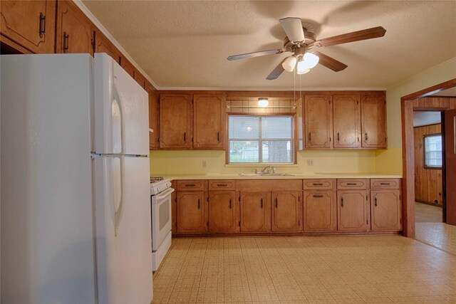 1116-C Simpson St, Schulenburg, TX 78956 - kitchen featuring white appliances, a ceiling fan, light floors, a sink, and brown cabinetry