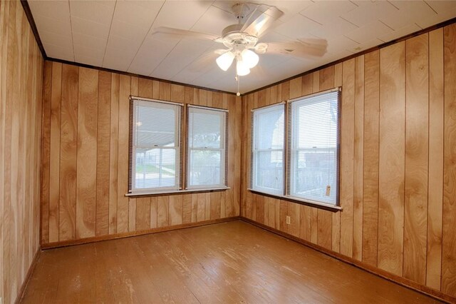 1116-C Simpson St, Schulenburg, TX 78956 - empty room featuring wood-type flooring, wood walls, crown molding, and ceiling fan