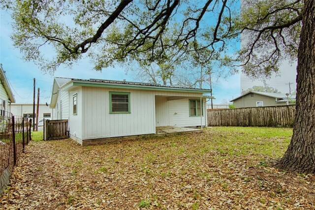 1116-C Simpson St, Schulenburg, TX 78956 - rear view of house with a fenced backyard, a lawn, and metal roof