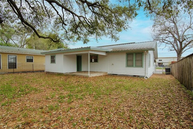 1116-C Simpson St, Schulenburg, TX 78956 - rear view of property featuring a fenced backyard, metal roof, a patio area, and a yard