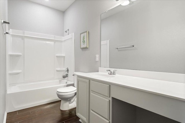 full bath featuring vanity, shower / bath combination, toilet, a textured wall, and wood finished floors