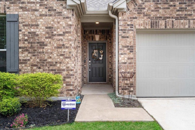 property entrance featuring a garage and brick siding