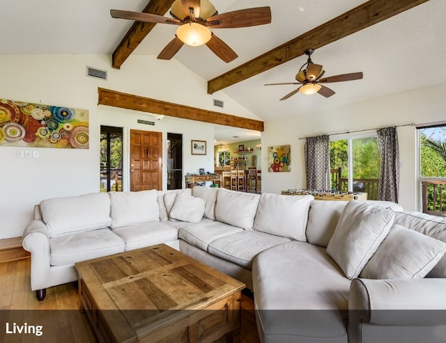 living area featuring wood finished floors, visible vents, vaulted ceiling with beams, and ceiling fan