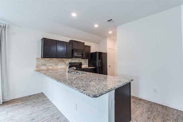 1713 Pahmeyer Path, New Braunfels, TX 78130 - kitchen with black appliances, decorative backsplash, light wood-style floors, light stone countertops, and dark brown cabinets