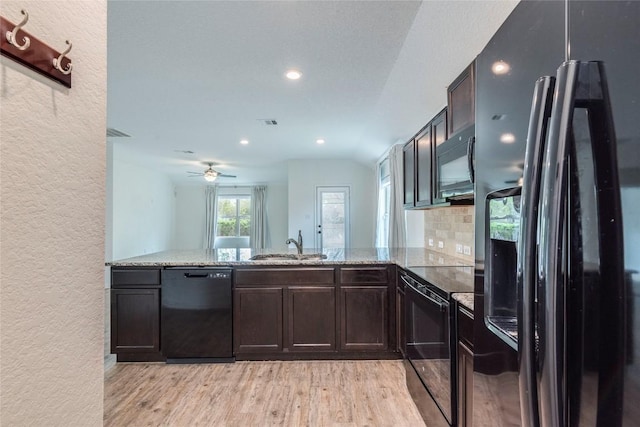 1713 Pahmeyer Path, New Braunfels, TX 78130 - kitchen featuring black appliances, a textured wall, light stone countertops, light wood finished floors, and recessed lighting