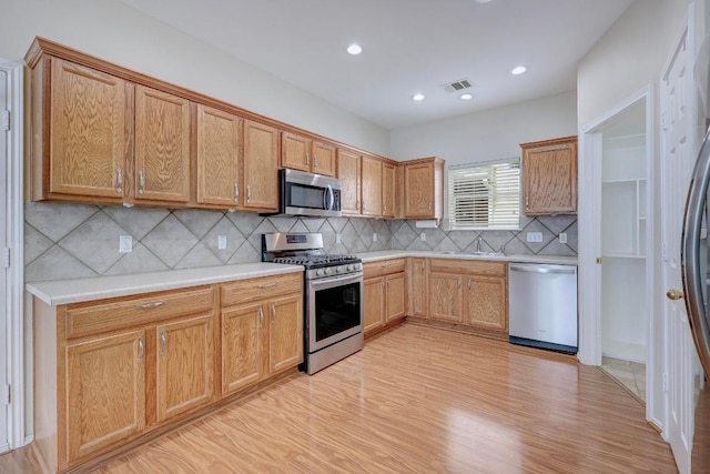 1012 Peyton Pl, Cedar Park, TX 78613 - kitchen featuring stainless steel appliances, backsplash, light wood-style floors, light countertops, and recessed lighting