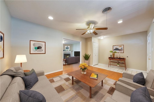 2004 Teakwood Dr, Austin, TX 78757 - living area with ceiling fan, light wood-style flooring, a glass covered fireplace, recessed lighting, and baseboards