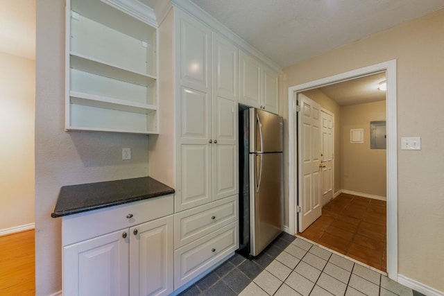 2004 Teakwood Dr, Austin, TX 78757 - kitchen featuring freestanding refrigerator, white cabinets, dark countertops, dark tile patterned floors, and open shelves