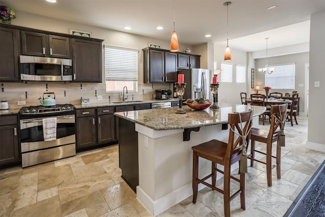 11913 Natures Bnd, Austin, TX 78753 - kitchen with appliances with stainless steel finishes, plenty of natural light, dark brown cabinetry, a kitchen bar, and recessed lighting