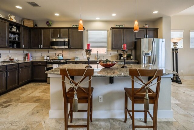 11913 Natures Bnd, Austin, TX 78753 - kitchen featuring stainless steel appliances, dark brown cabinetry, a kitchen breakfast bar, and recessed lighting