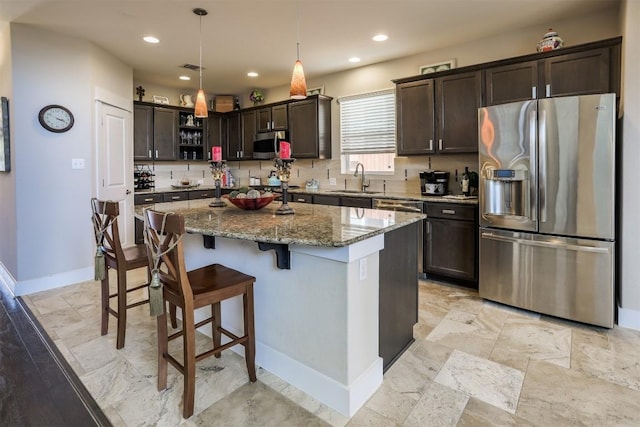 11913 Natures Bnd, Austin, TX 78753 - kitchen with stainless steel appliances, dark brown cabinetry, stone countertops, a center island, and recessed lighting