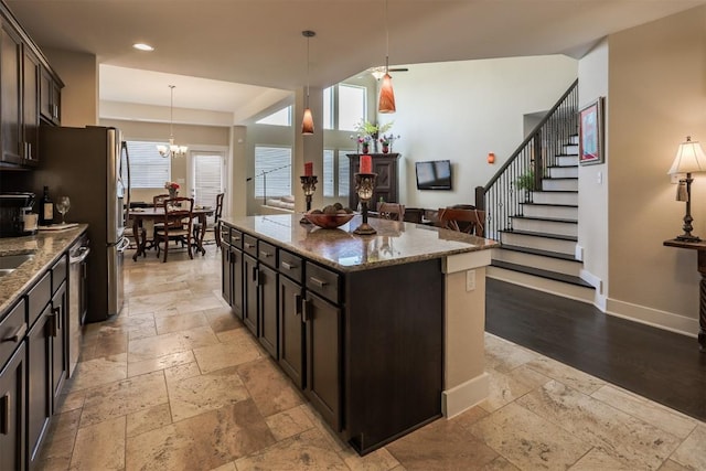 11913 Natures Bnd, Austin, TX 78753 - kitchen with stone tile flooring, a kitchen island, stone countertops, decorative light fixtures, and open floor plan