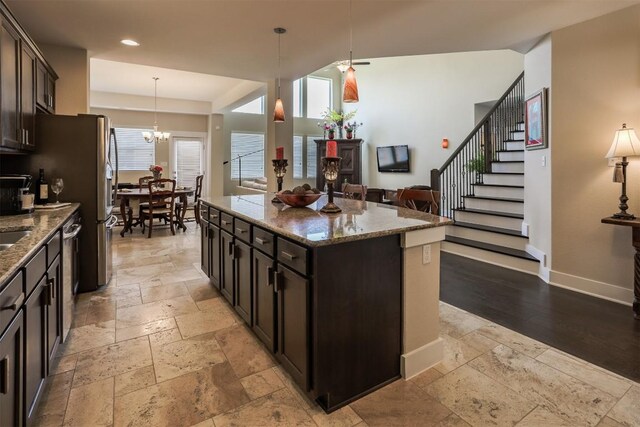 11913 Natures Bnd, Austin, TX 78753 - kitchen with stone tile floors, a kitchen island, stone counters, pendant lighting, and open floor plan