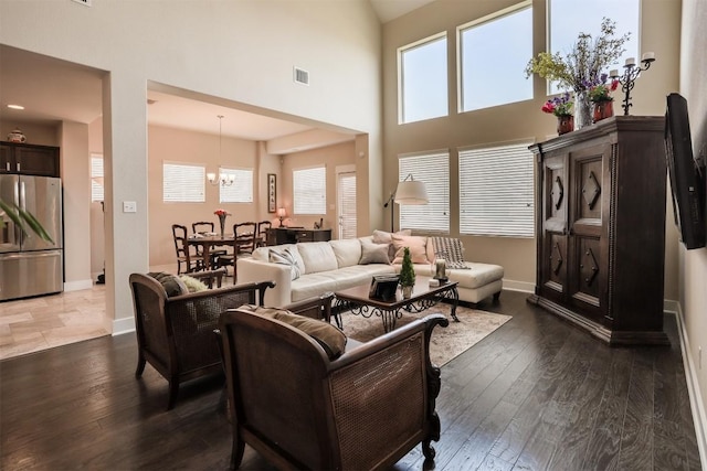 11913 Natures Bnd, Austin, TX 78753 - living room featuring dark wood-style floors, a high ceiling, and a chandelier