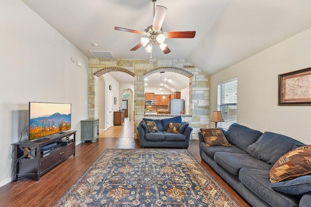 1411 Rowan Dr, Georgetown, TX 78628 - living room with arched walkways, dark wood-style floors, a ceiling fan, vaulted ceiling, and ornate columns