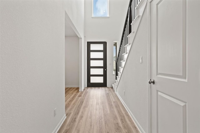 708 Leeward Pass, Leander, TX 78641 - doorway featuring light wood-type flooring, stairs, and a towering ceiling