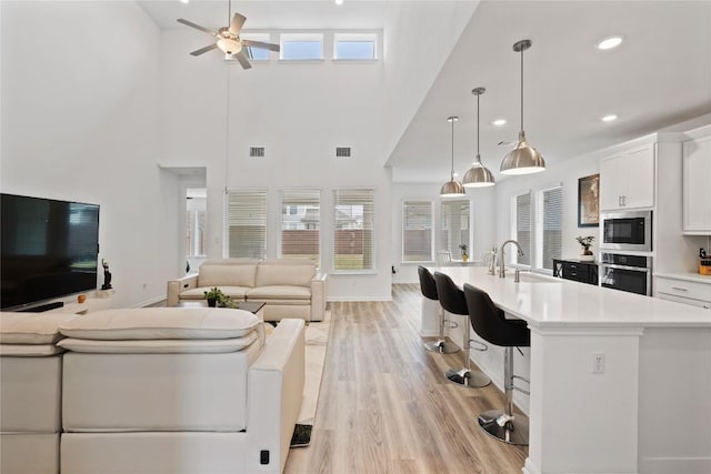 708 Leeward Pass, Leander, TX 78641 - living room with ceiling fan, a high ceiling, light wood finished floors, and recessed lighting