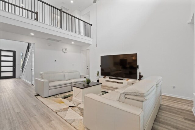 708 Leeward Pass, Leander, TX 78641 - living room with light wood-style flooring, stairway, a towering ceiling, and recessed lighting