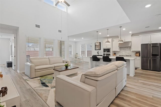 708 Leeward Pass, Leander, TX 78641 - living room featuring light wood-type flooring, ceiling fan, recessed lighting, and a towering ceiling
