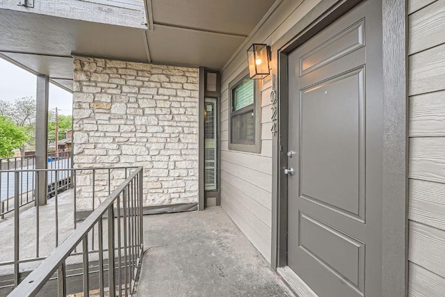 1510 W N Loop Blvd Unit 1024, Austin, TX 78756 - view of exterior entry featuring stone siding and a porch