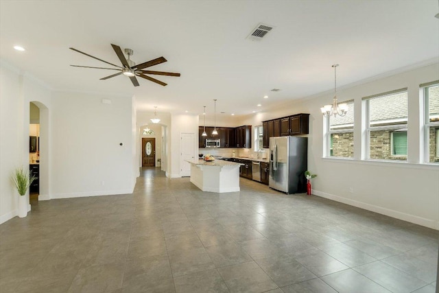 unfurnished living room with arched walkways, ornamental molding, ceiling fan with notable chandelier, and visible vents