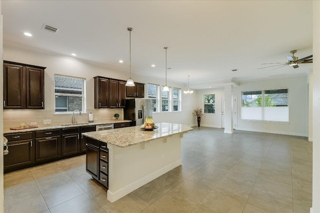 kitchen with a center island, tasteful backsplash, a sink, open floor plan, and stainless steel appliances