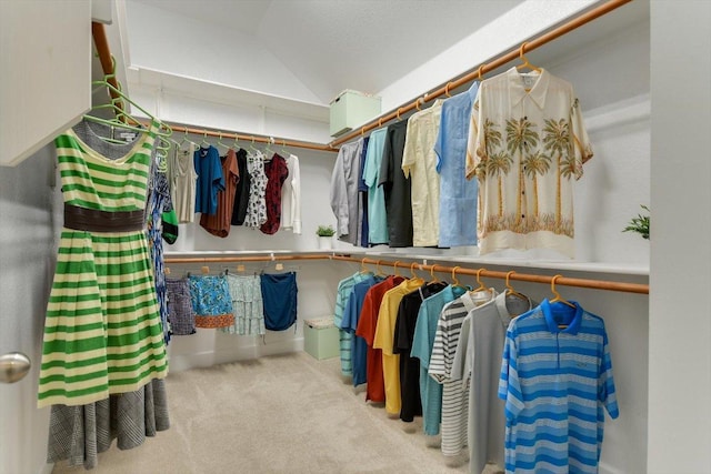 walk in closet with vaulted ceiling and carpet flooring