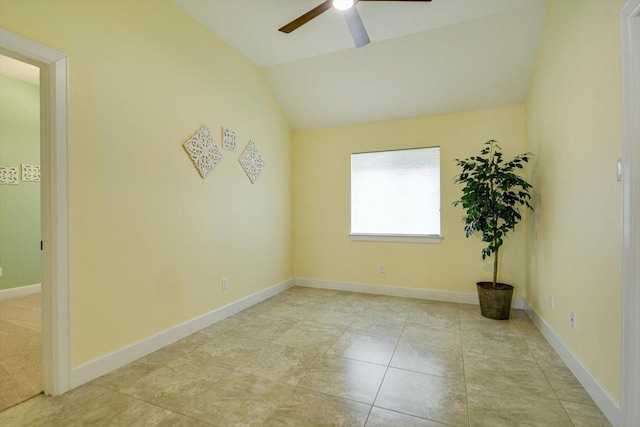 empty room featuring baseboards, ceiling fan, and vaulted ceiling