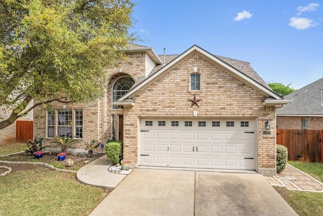 traditional-style home featuring brick siding, roof with shingles, concrete driveway, an attached garage, and fence