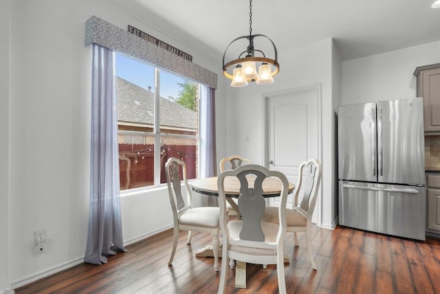 dining room with dark wood finished floors, baseboards, and an inviting chandelier