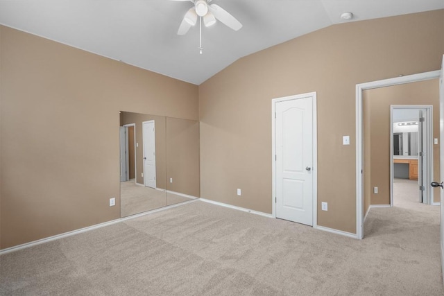 unfurnished bedroom featuring carpet flooring, baseboards, ceiling fan, and lofted ceiling