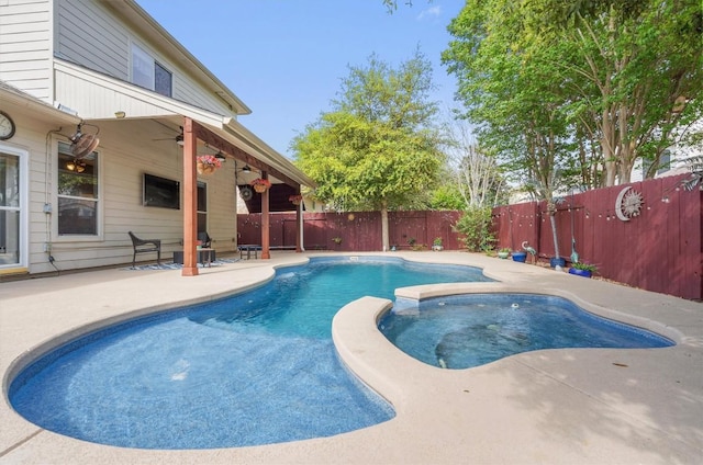 view of swimming pool featuring a pool with connected hot tub, a patio, a ceiling fan, and a fenced backyard