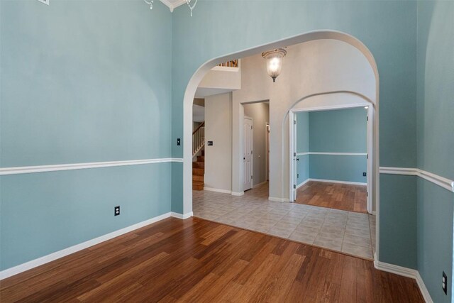 318 Ridge Run Dr, Georgetown, TX 78628 - spare room with wood finished floors, arched walkways, stairway, baseboards, and a high ceiling