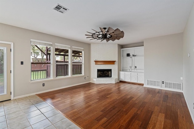 318 Ridge Run Dr, Georgetown, TX 78628 - unfurnished living room featuring wood finished floors, a fireplace, baseboards, and ceiling fan