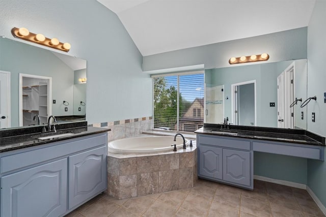318 Ridge Run Dr, Georgetown, TX 78628 - bathroom with vaulted ceiling, a bath, two vanities, and tile patterned floors