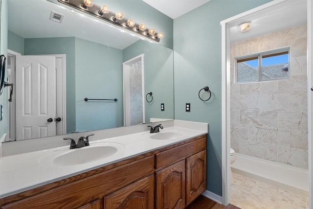 318 Ridge Run Dr, Georgetown, TX 78628 - bathroom featuring double vanity, toilet, and a tile shower