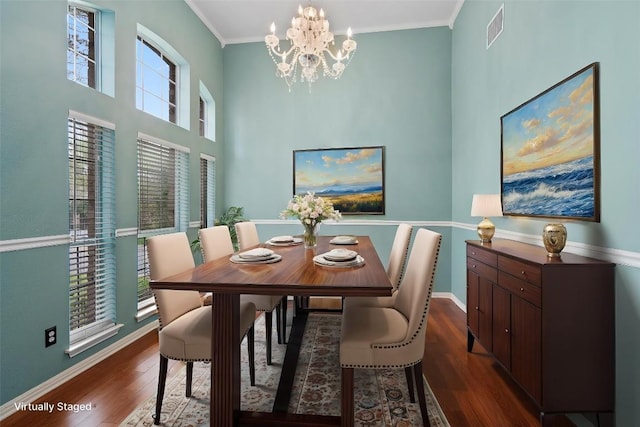 318 Ridge Run Dr, Georgetown, TX 78628 - dining area featuring a chandelier, dark wood-type flooring, baseboards, crown molding, and a towering ceiling