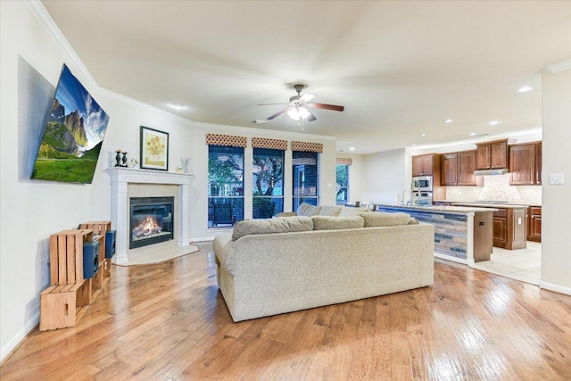 431 Ridgetop Bnd, Cedar Park, TX 78613 - living room featuring light wood-style flooring, a ceiling fan, crown molding, a premium fireplace, and recessed lighting