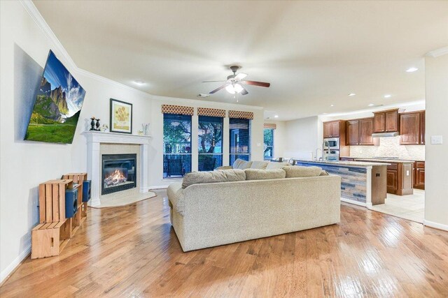 431 Ridgetop Bnd, Cedar Park, TX 78613 - living room featuring light wood-style flooring, a ceiling fan, crown molding, a premium fireplace, and recessed lighting