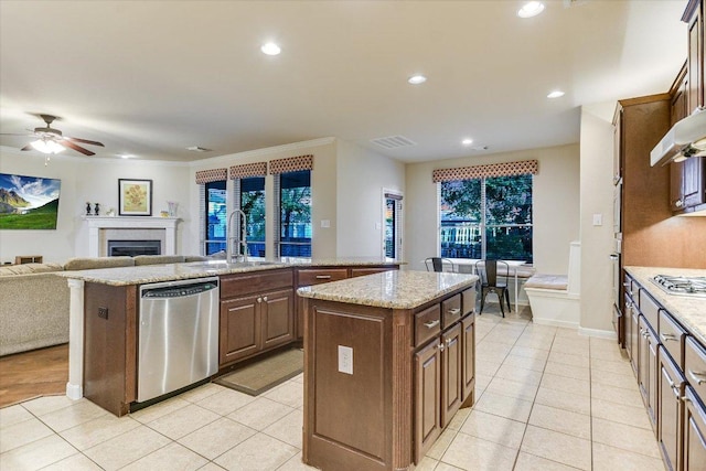431 Ridgetop Bnd, Cedar Park, TX 78613 - kitchen featuring stainless steel appliances, a center island with sink, a sink, ceiling fan, and a fireplace