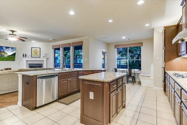 431 Ridgetop Bnd, Cedar Park, TX 78613 - kitchen featuring stainless steel appliances, a center island with sink, a sink, ceiling fan, and a fireplace