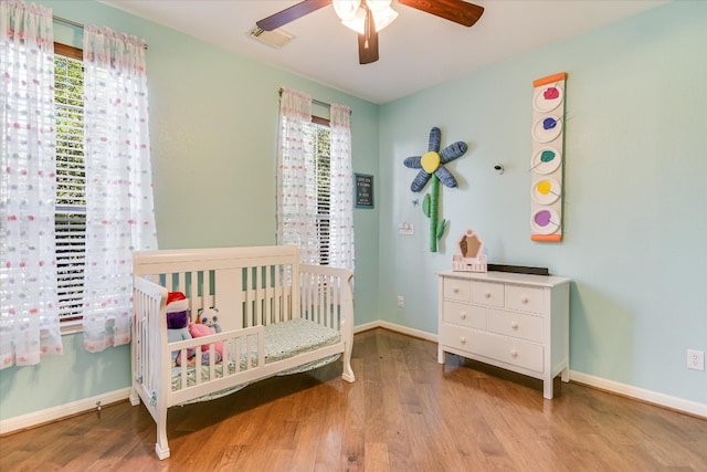 431 Ridgetop Bnd, Cedar Park, TX 78613 - bedroom with wood finished floors, a crib, baseboards, and ceiling fan