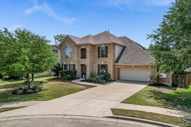 431 Ridgetop Bnd, Cedar Park, TX 78613 - view of front of home with brick siding, a garage, a front lawn, driveway, and a shingled roof