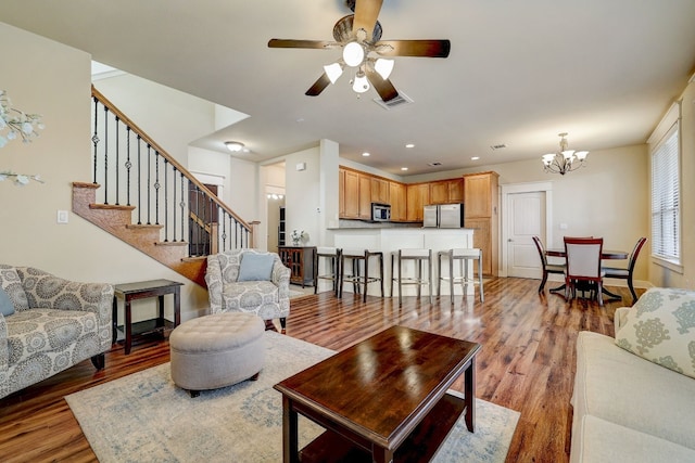 living area with stairs, ceiling fan with notable chandelier, light wood-style flooring, visible vents, and recessed lighting