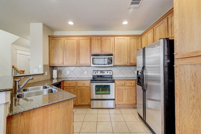 kitchen featuring a sink, light tile patterned floors, stainless steel appliances, a peninsula, and visible vents